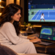 Mujer consultando estadísticas y apuestas de tenis en su portátil mientras ve un partido en televisión